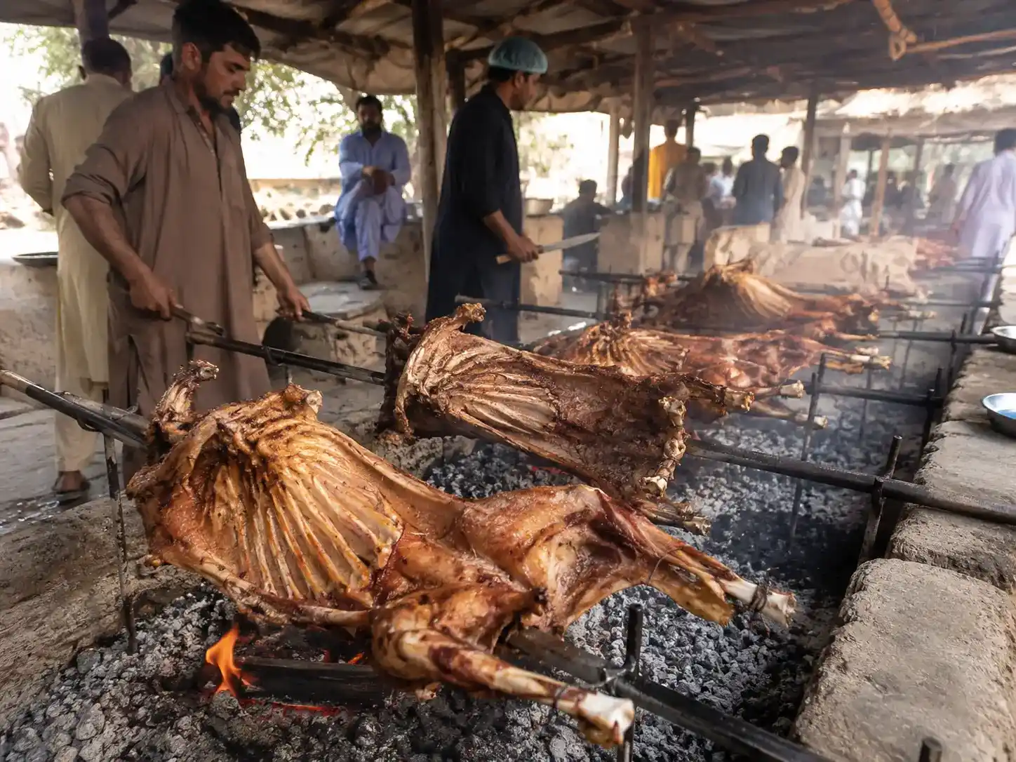 Whole Sajji roasting over open coals, a traditional food of Balochistan